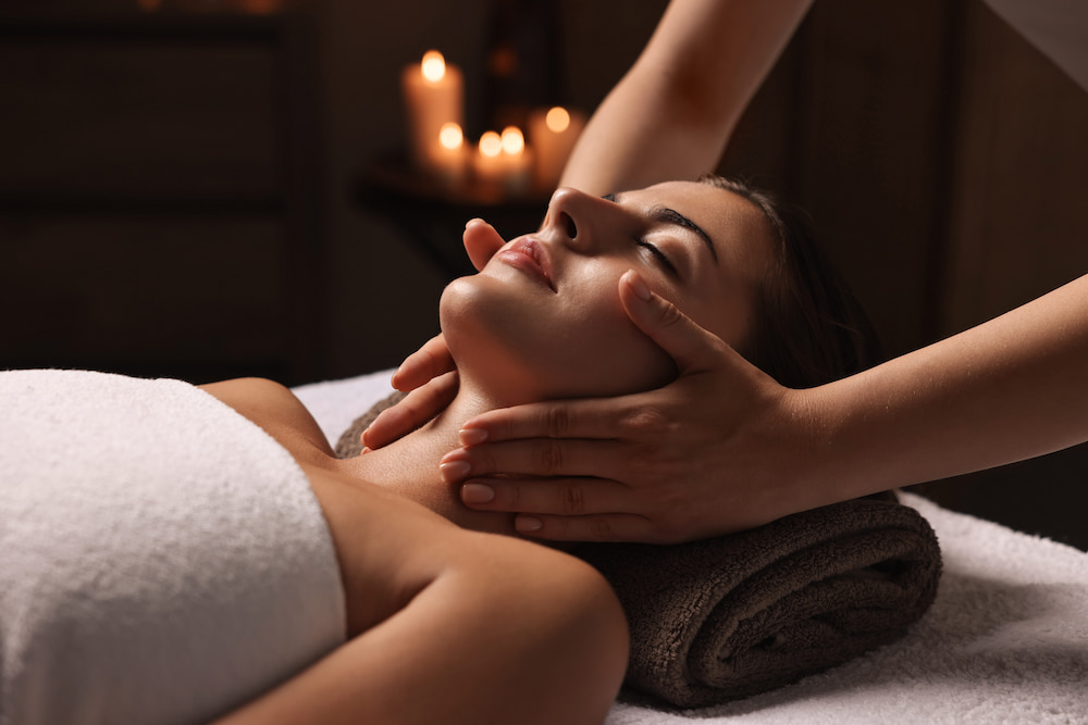 a woman relaxes while getting a soothing massage on her head and neck