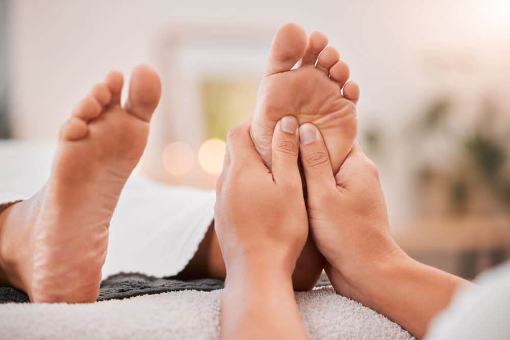 Massage therapist applies targeted pressure to a patient’s foot