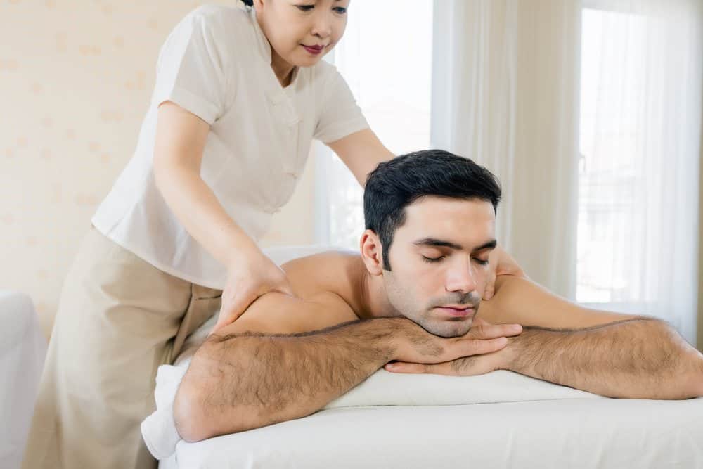 A man relaxes while receiving a deep stretching massage