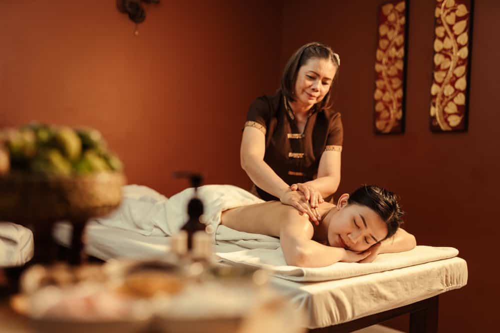 woman receives a modern thai massage laying on a table in a spa