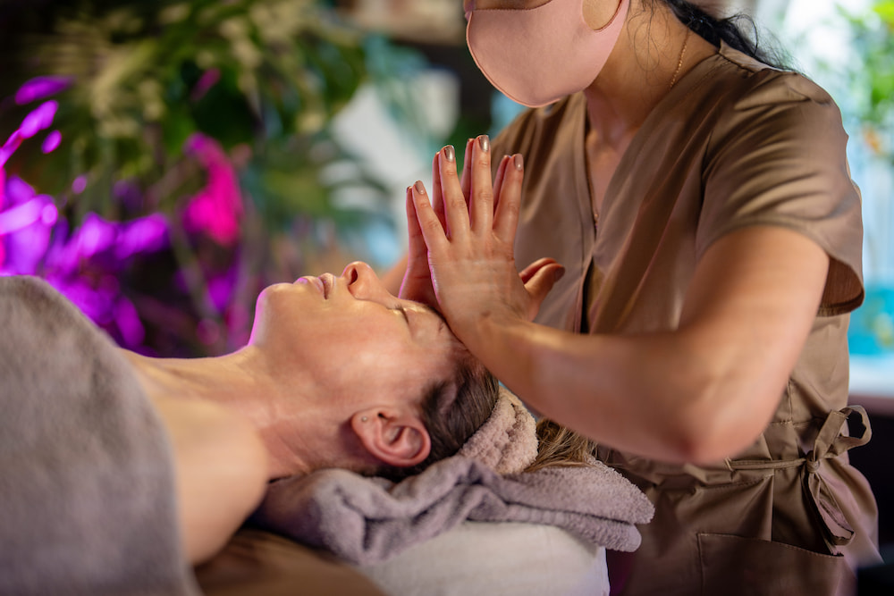 A woman receives a Thai massage for headaches. This technique follows traditional Thai bodywork