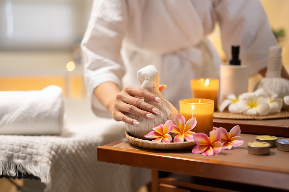 A woman holding an herbal compress in a spa