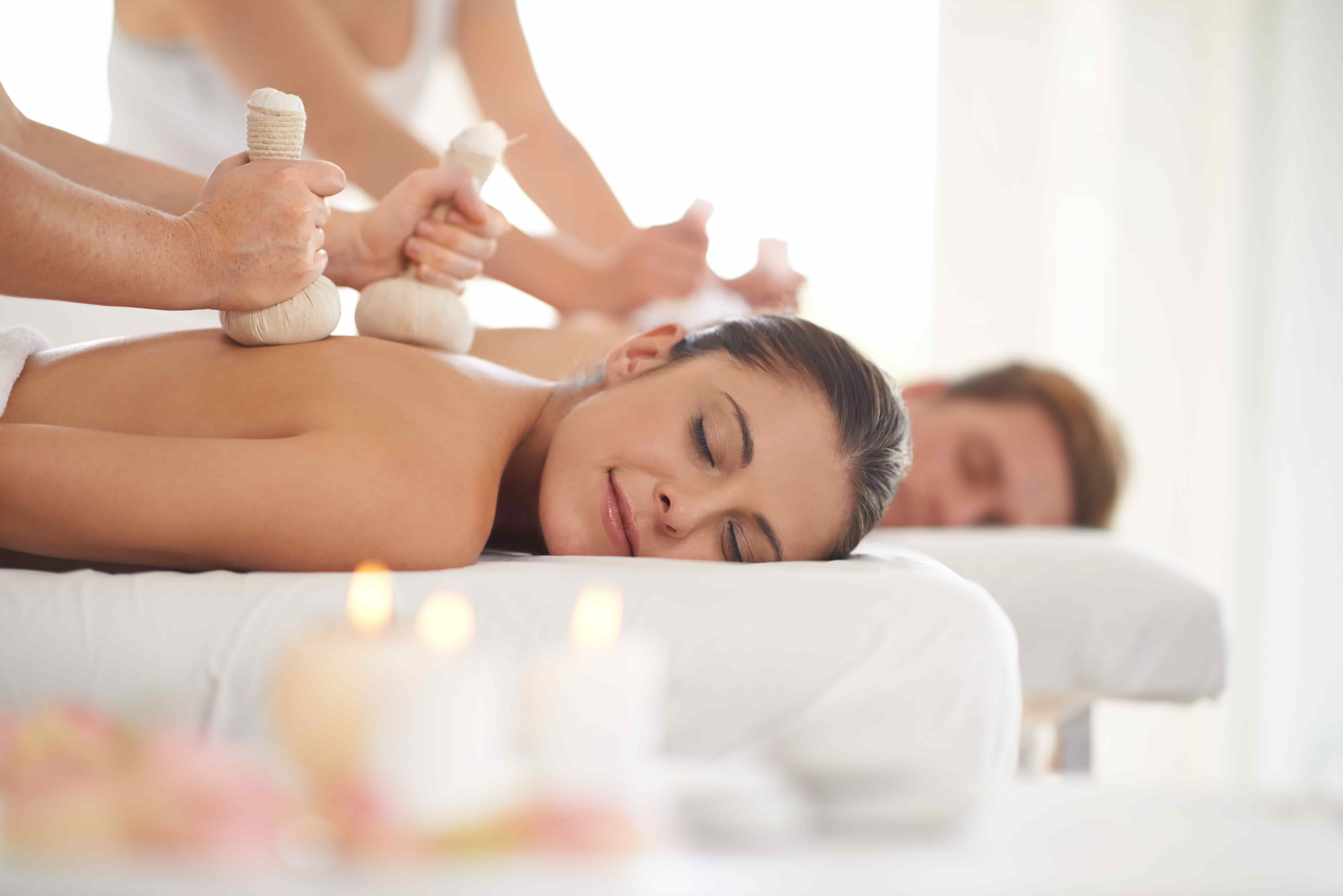 A couple receiving a Thai massage with a herbal compress