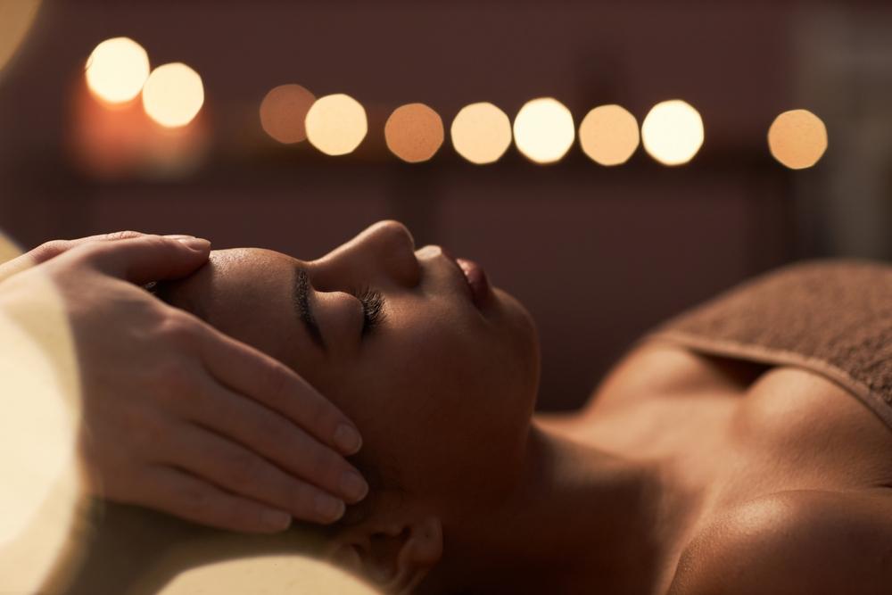 A calm spa room with dim lighting making a guest fall asleep during her relaxing massage.