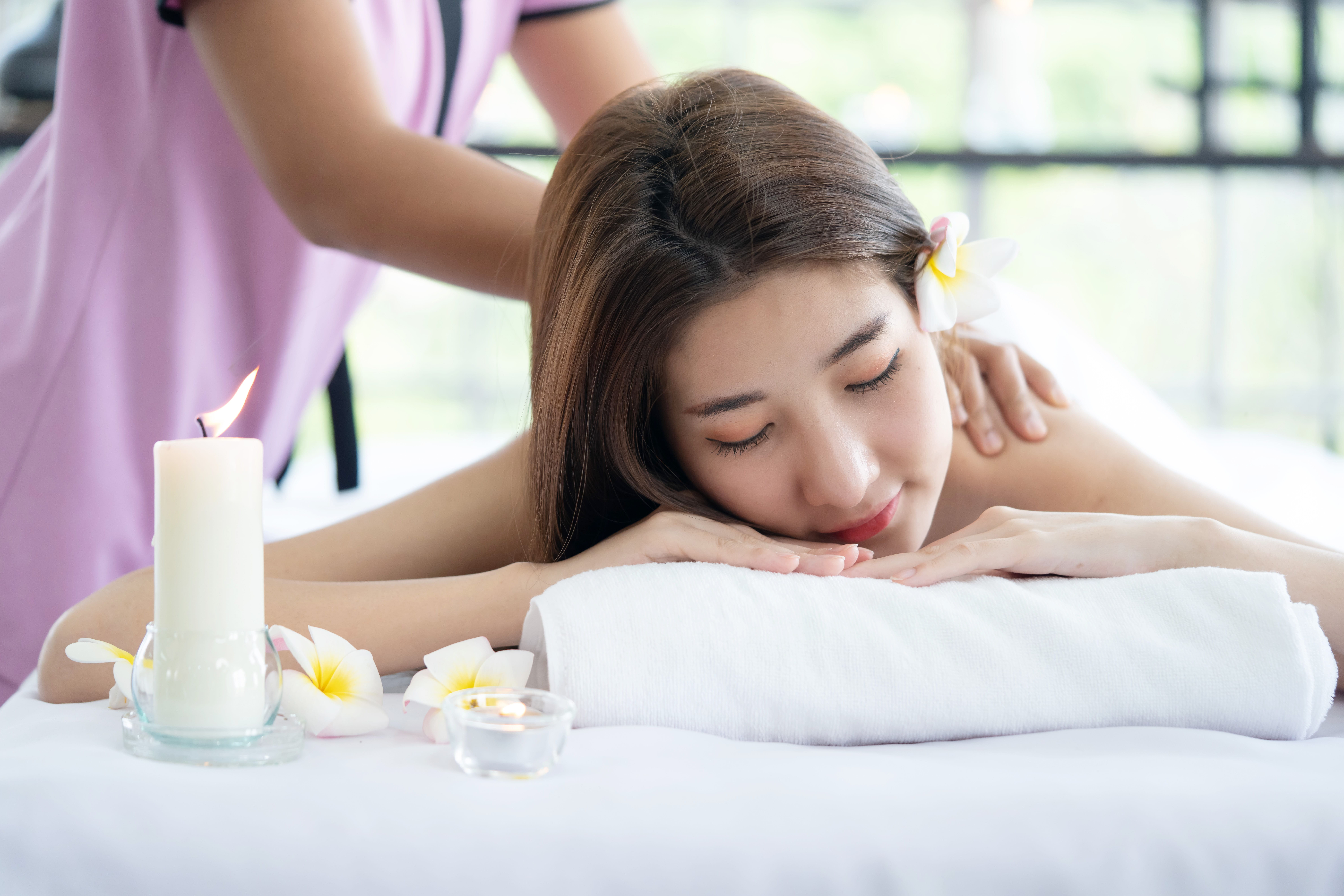 A woman enjoys a gentle back massage while on period days at a quiet spa.