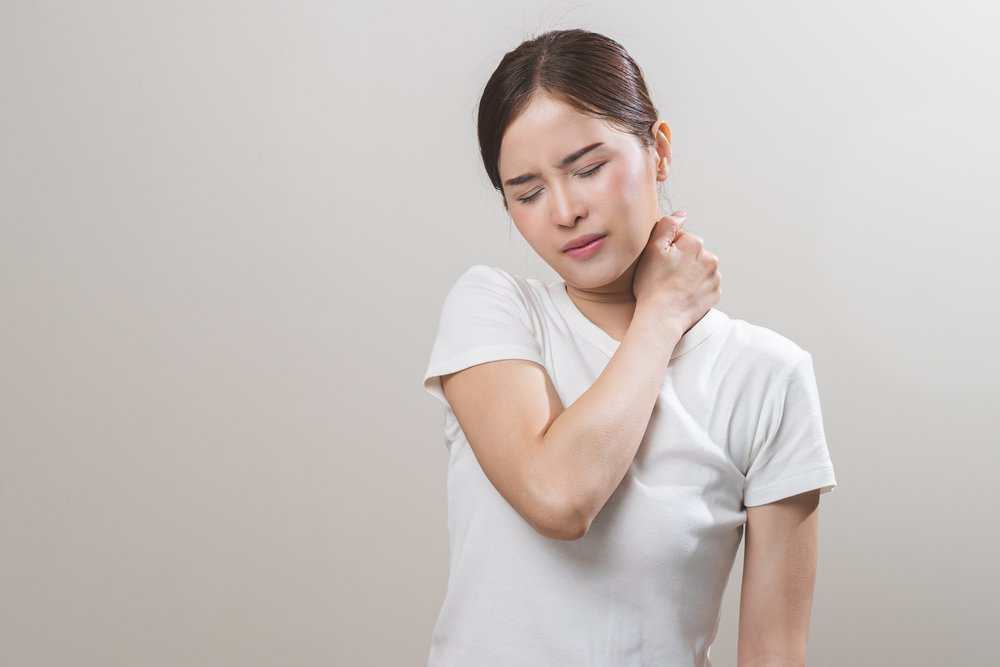A woman suffering from back and neck pain