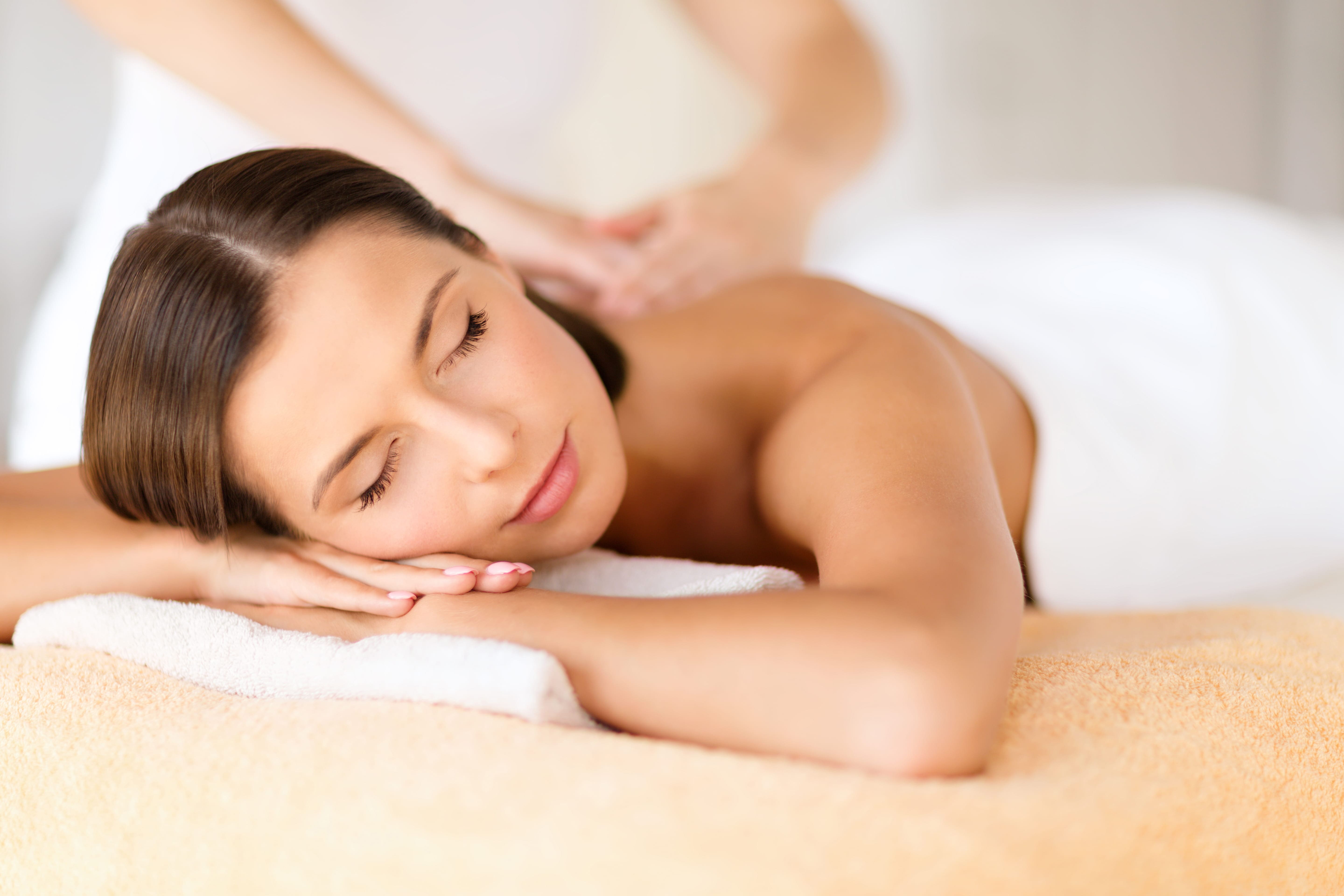 A woman enjoying a massage after comparing Swedish massage vs. deep tissue vs. hot stone.